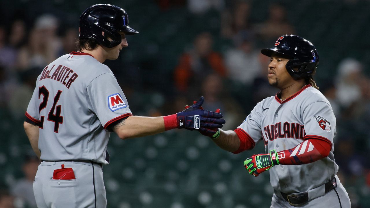 Cincinnati Reds' Matt McLain (9) and Gavin Lux (2) celebrate after McLain scored in the third inning of a baseball game against the Chicago Cubs, Saturday, Sept. 20, 2025, in Cincinnati.