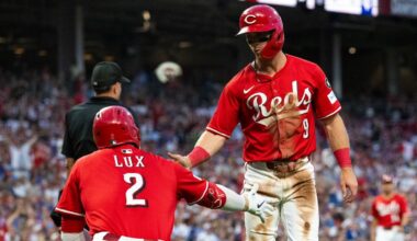 Cincinnati Reds' Matt McLain (9) and Gavin Lux (2) celebrate after McLain scored in the third inning of a baseball game against the Chicago Cubs, Saturday, Sept. 20, 2025, in Cincinnati.