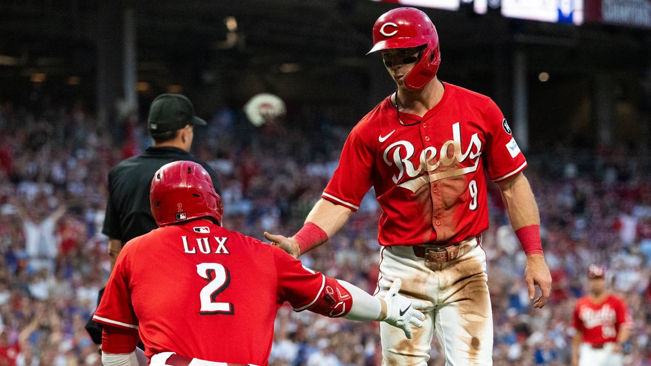 Cincinnati Reds' Matt McLain (9) and Gavin Lux (2) celebrate after McLain scored in the third inning of a baseball game against the Chicago Cubs, Saturday, Sept. 20, 2025, in Cincinnati.
