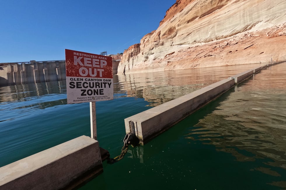 FILE - A sign reading "keep out" is displayed just upstream of Glen Canyon Dam at Lake Powell,...