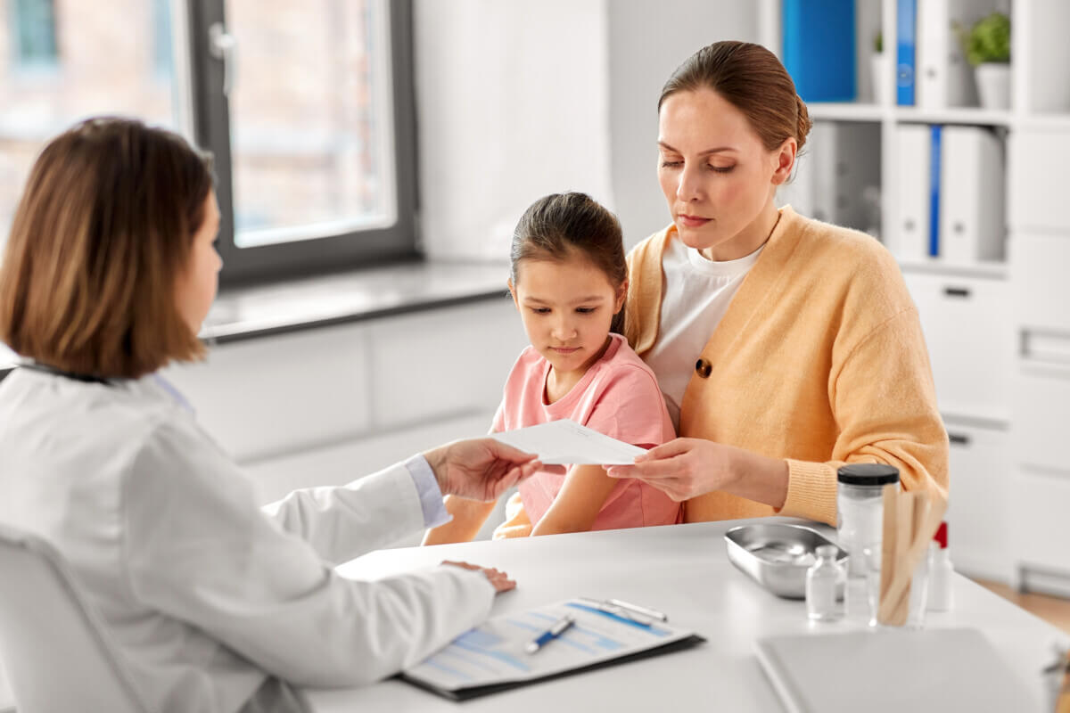 Doctor giving woman a prescription for her child