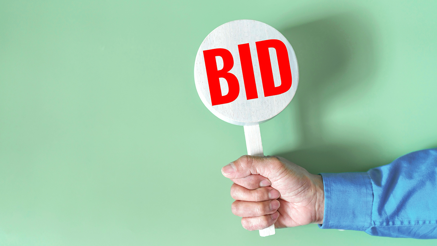 Businessman hold a bid sign Buying, Bidding Concepts, Wooden sign with the word Bid