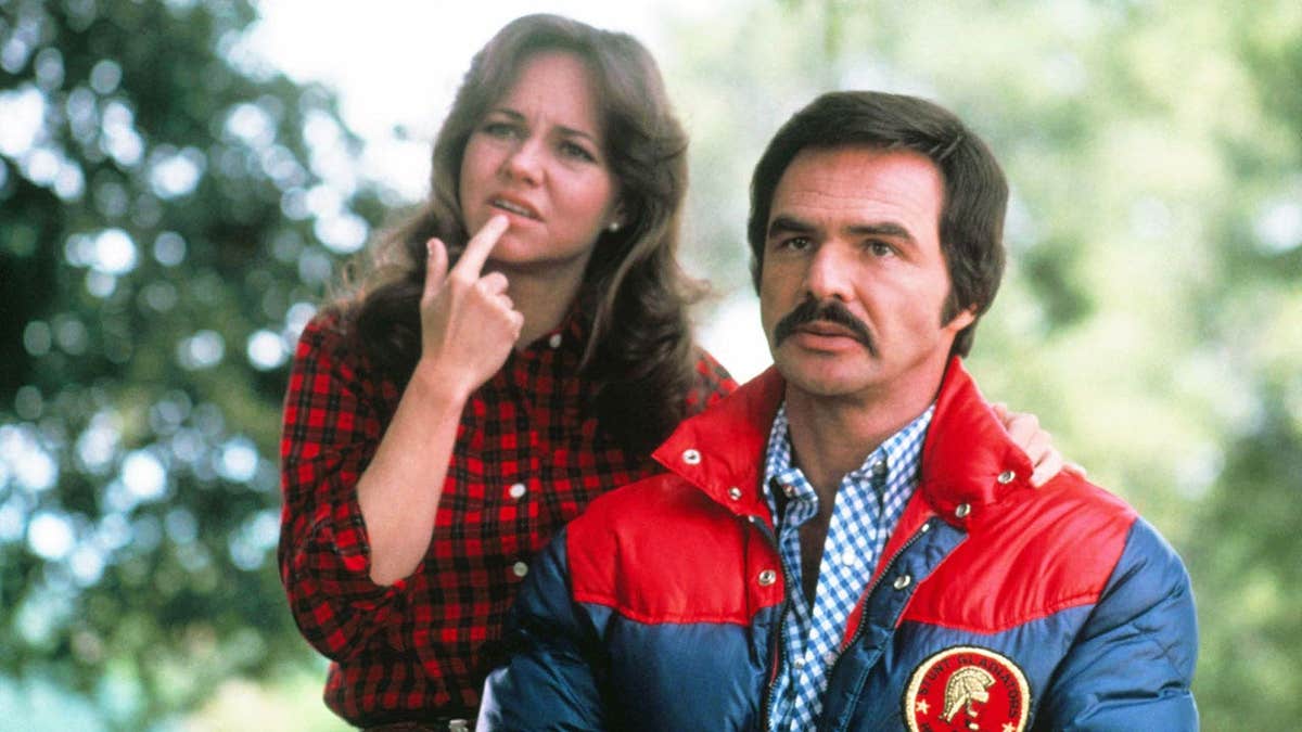 Sally Field and Burt Reynolds outdoors looking perplexed.