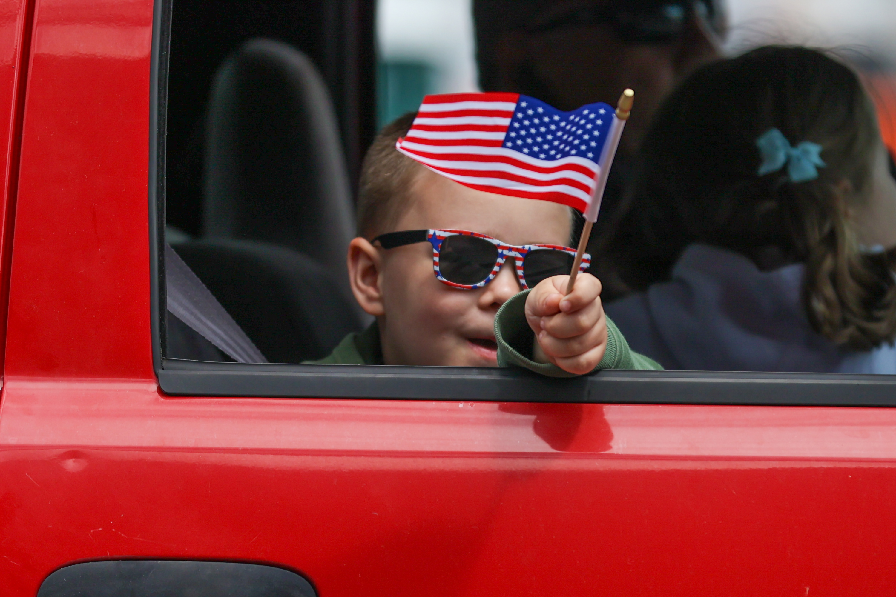 A member of the parade waves a U.S. flag during...