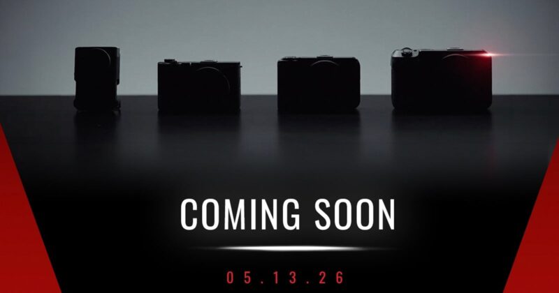 Four silhouetted cameras on a dark background, with one emitting a small red light. Text below reads "COMING SOON" and "05.13.26" in white and red on a black and red gradient background.
