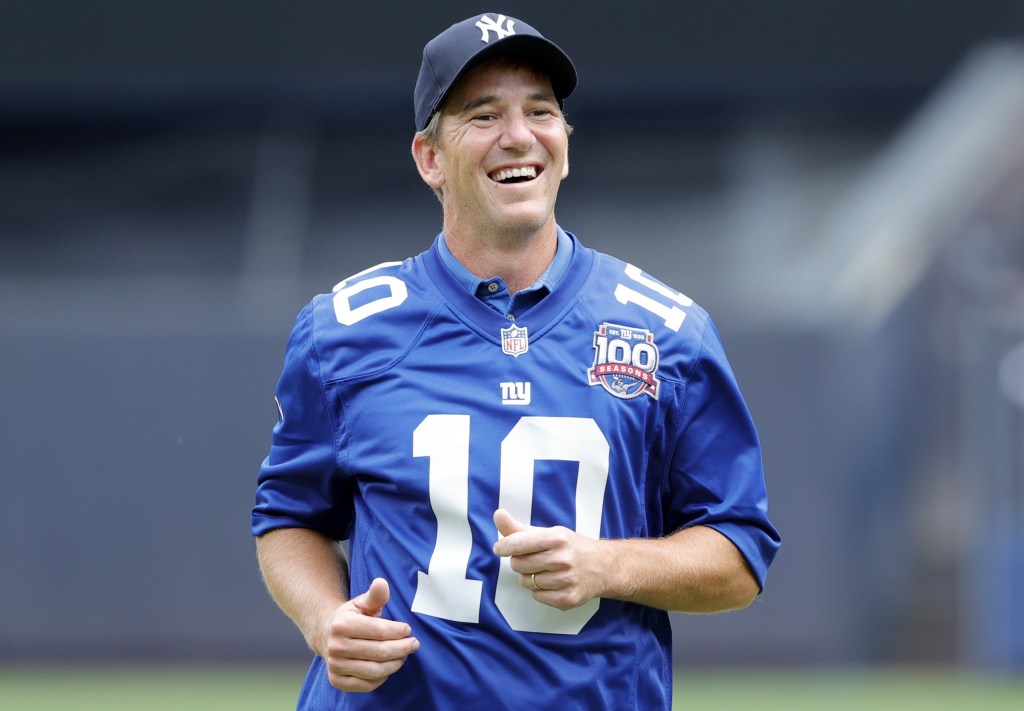 Eli Manning is all smiles after throwing out a ceremonial first pitch during a Yankees game in 2024.