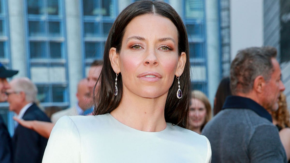 Evangeline Lilly walking on red carpet wearing white dress