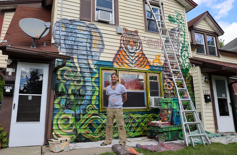 Artist David Smart is painting zoo animals on the exterior of this rental property at 521 S. Wilbur Ave.