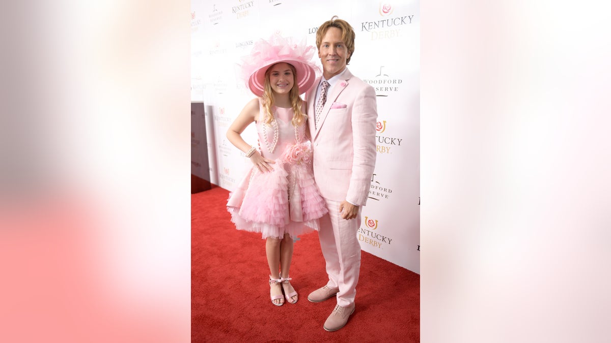 Dannielynn Birkhead and Larry Birkhead standing on the red carpet at the Kentucky Derby