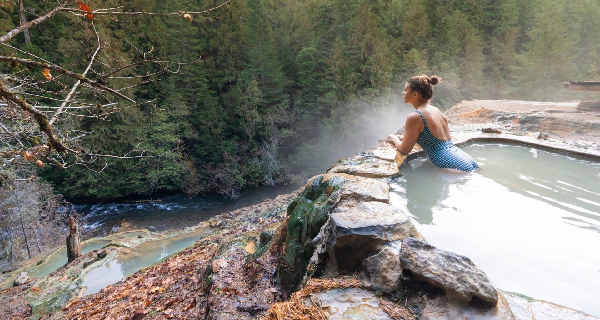 Woman with blue swimsuit relaxing in a hot pool in autumn, Umpqua Hot Springs, Douglas county, Oregon, United States