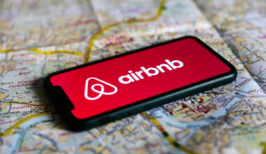 Airbnb logo displayed on a phone screen laying on a map of Krakow