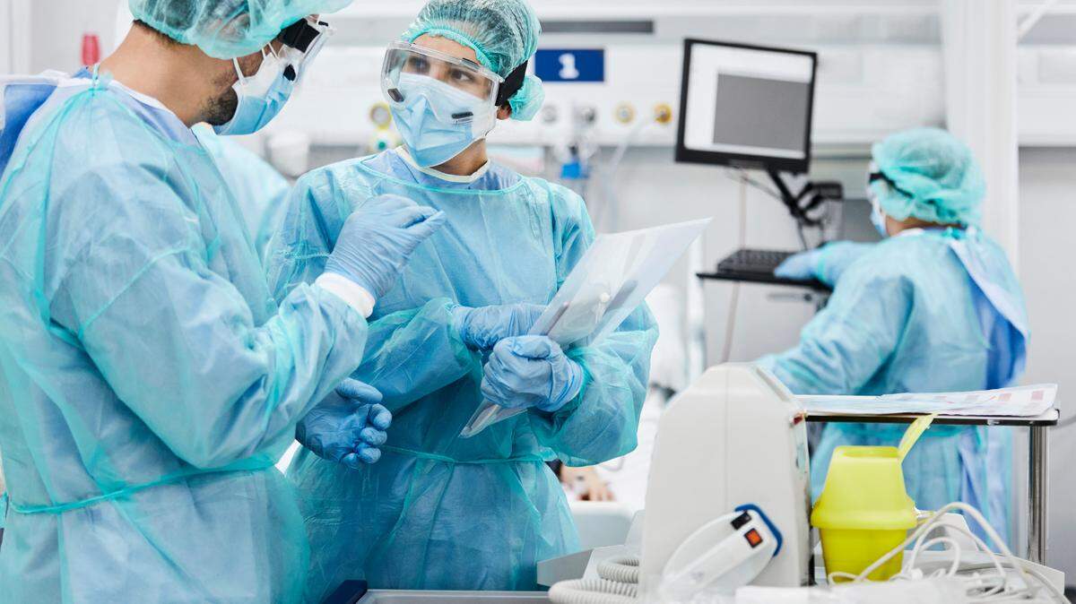 San Luis Obispo County hospitals are graded in The Leapfrog Group’s Hospital Safety Grade report for spring 2026. Male and female doctors discussing while standing in ICU. Healthcare workers are protective workwear. They are at hospital.