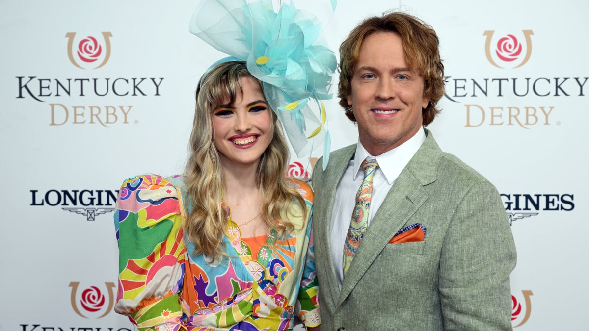 Dannielynn Birkhead and Larry Birkhead standing at Churchill Downs during the Kentucky Derby