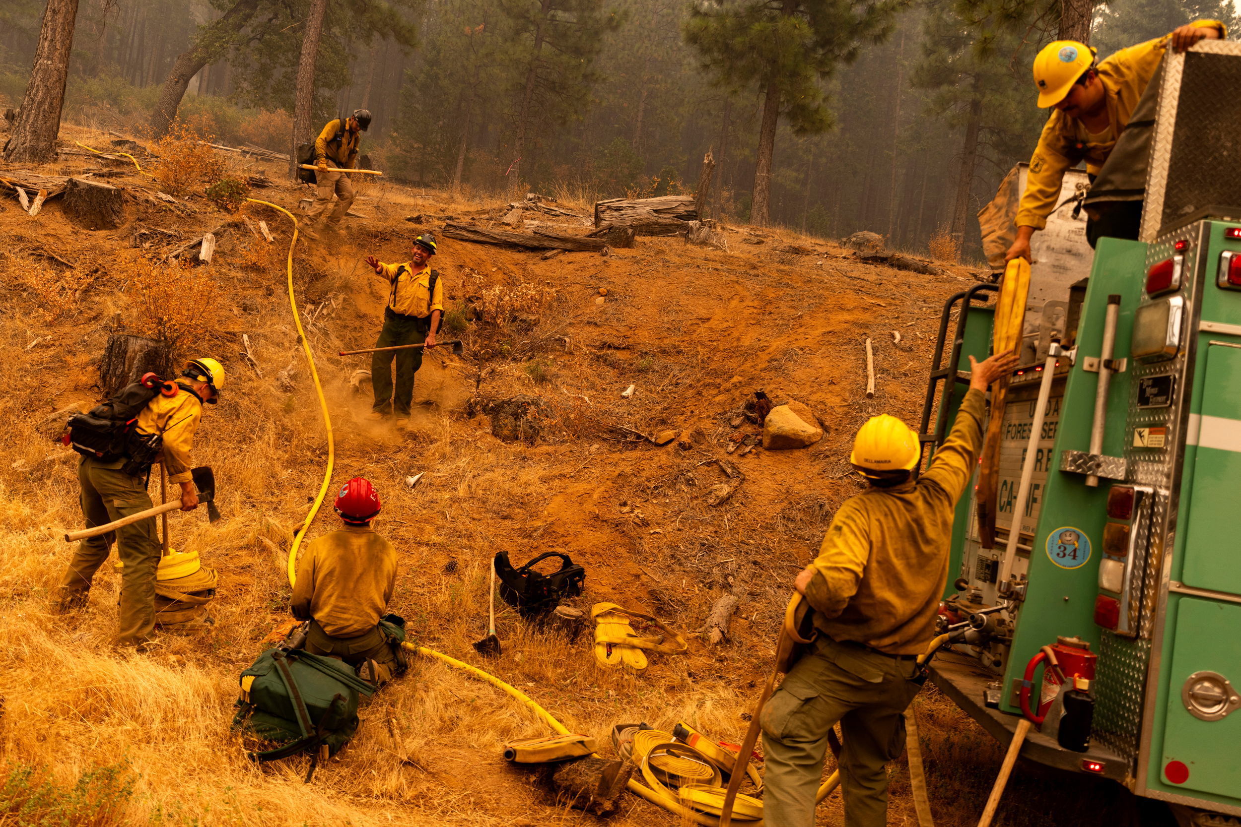 U.S. Forest Service firefighters prepare a hose lay on a hillside during the Park Fire in Tehama County, California, on July 27, 2024. Credit: Stephen Lam/San Francisco Chronicle via Getty Images