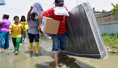 People carry their belongings as they evacuate due to flooding in Yaguachi, Ecuador, on Feb. 25, 2025. Credit: Marcos Pin/AFP via Getty Images