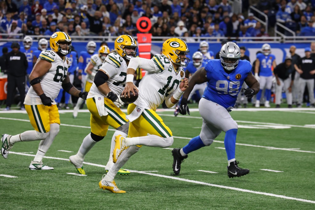 Green Bay Packers quarterback Jordan Love (10) runs with the ball while being pursued by Detroit Lions defensive end DJ Reader (98)