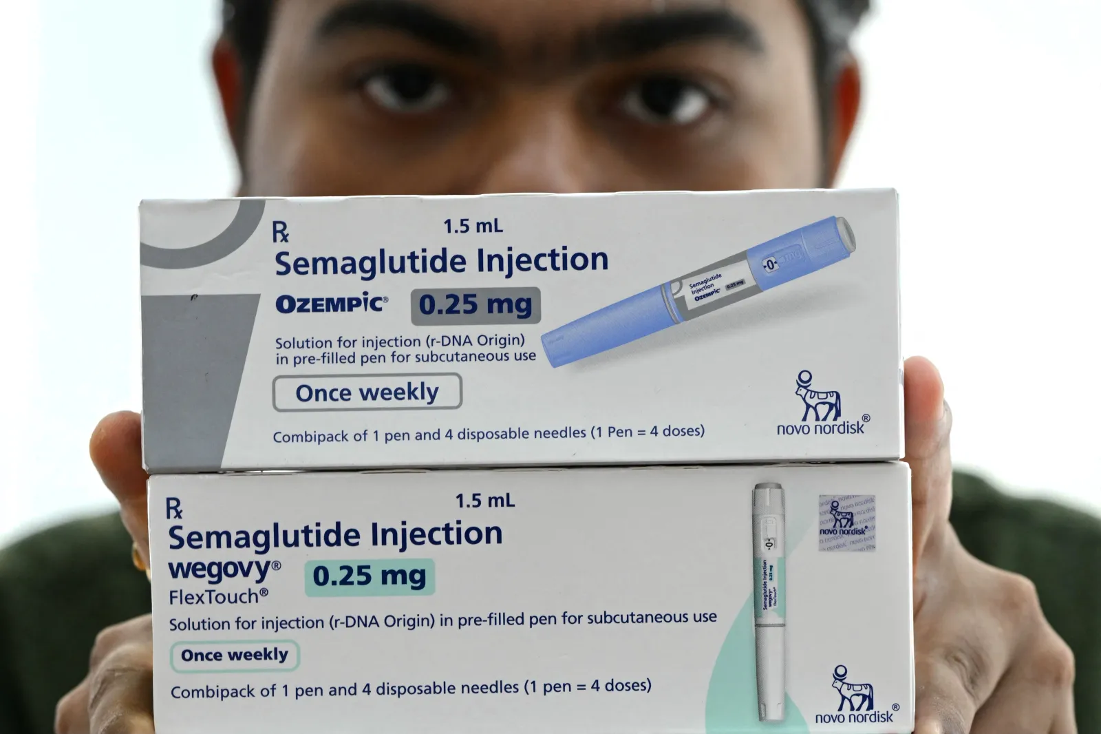 A medicine distributor displays packs of Ozempic and Wegovy self-injecting GLP-1 prefilled pens at his office in Thane, in western India, on March 20.