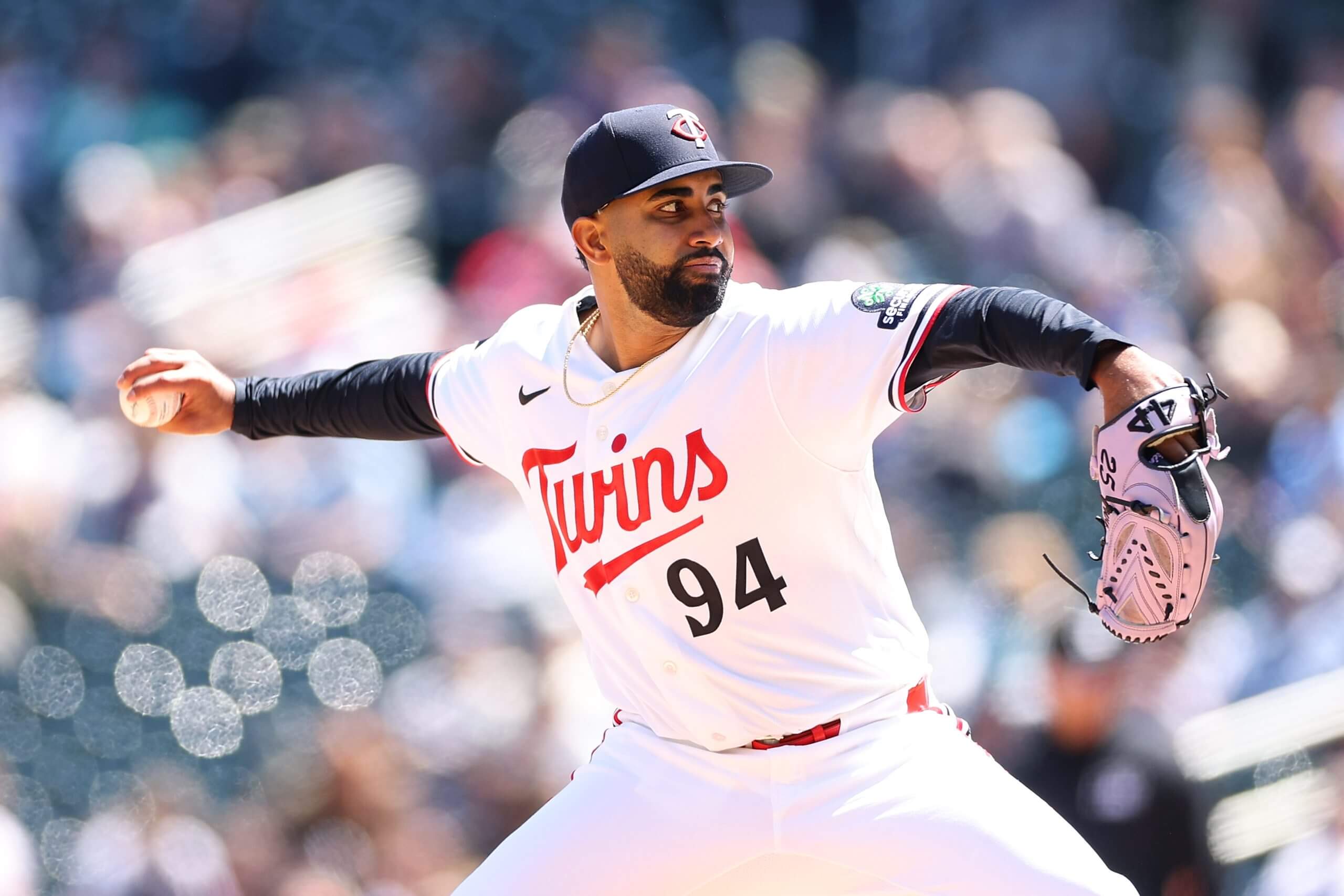 Yoendrys Gómez, wearing No. 94 on his jersey, rears back to pitch with the crowd blurred behind him.