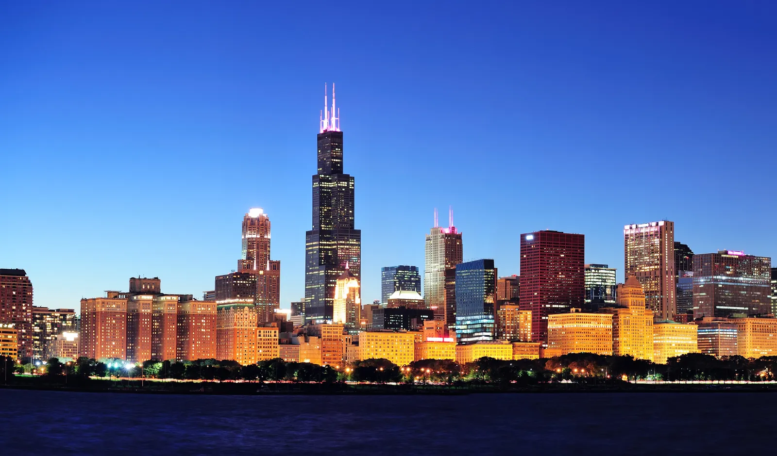 The Chicago city skyline at night, with the Willis Tower at the center.