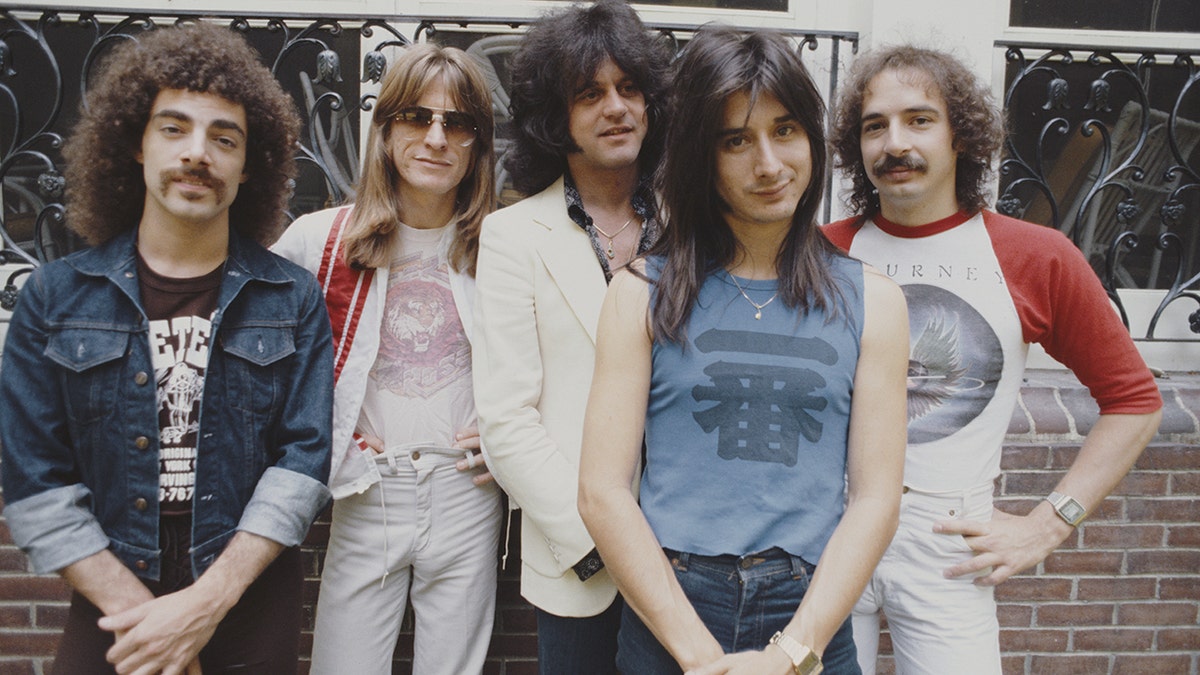 Journey band members Neal Schon, Ross Valory, Gregg Rolie, Steve Perry, and Steve Smith posing in New York