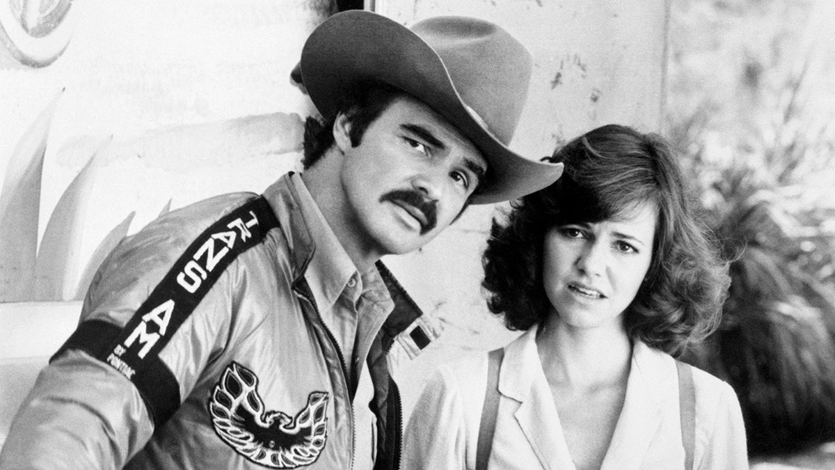 Burt Reynolds and Sally Field standing together appearing perplexed in a movie scene