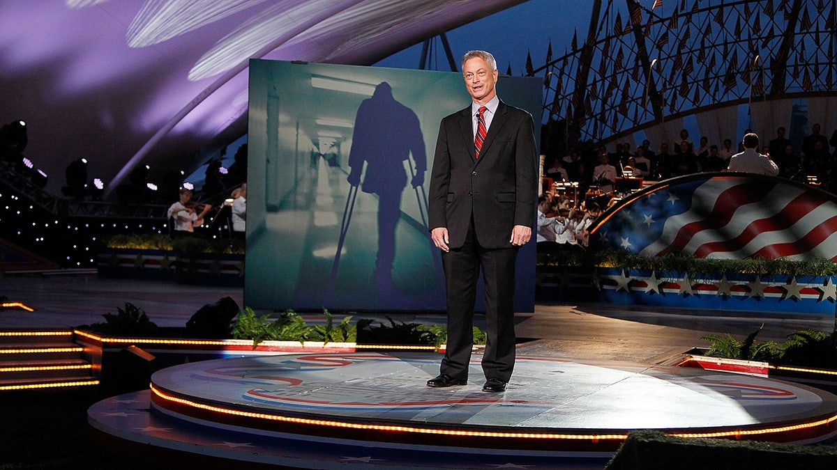 Gary Sinise in a suit and tie on stage