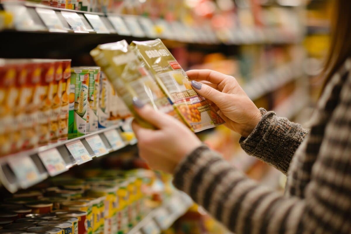Woman holding packaged food item at the grocery store