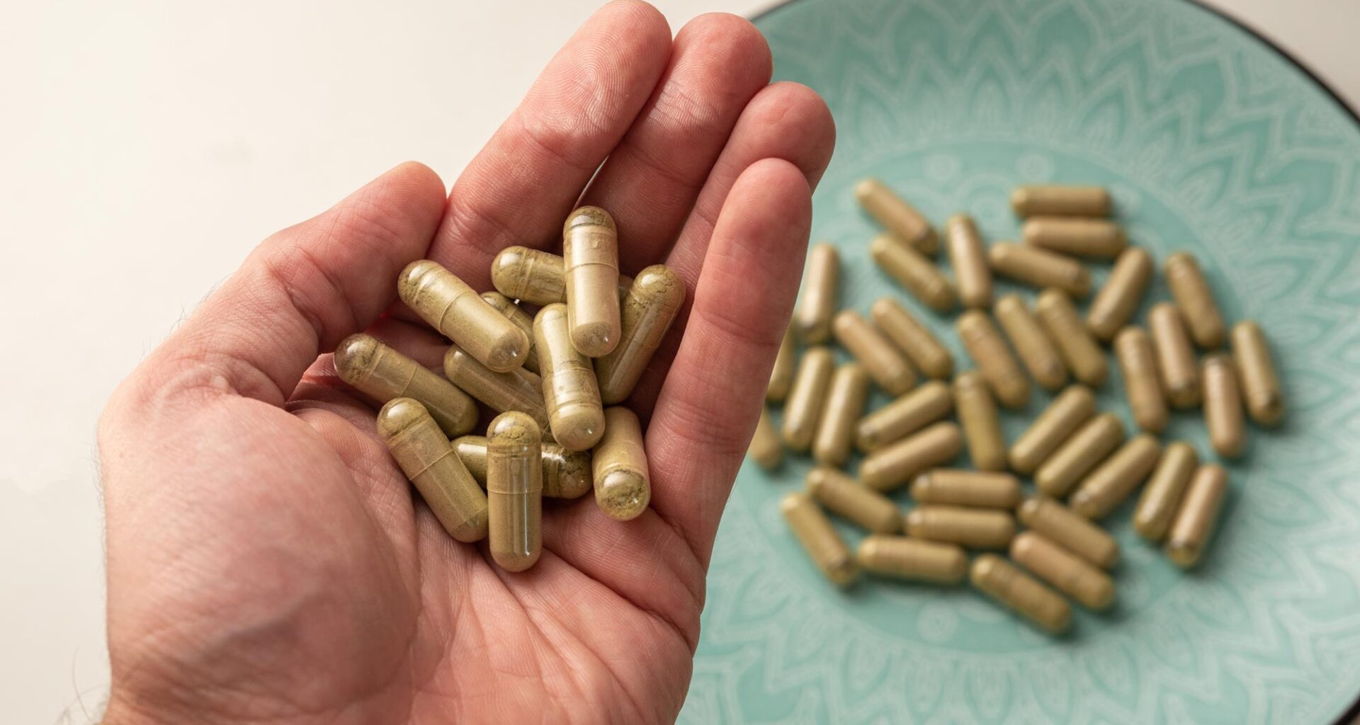 Hand Holding Kratom Pills