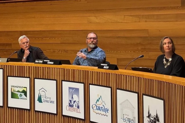 four county commissioners sit in a meeting room