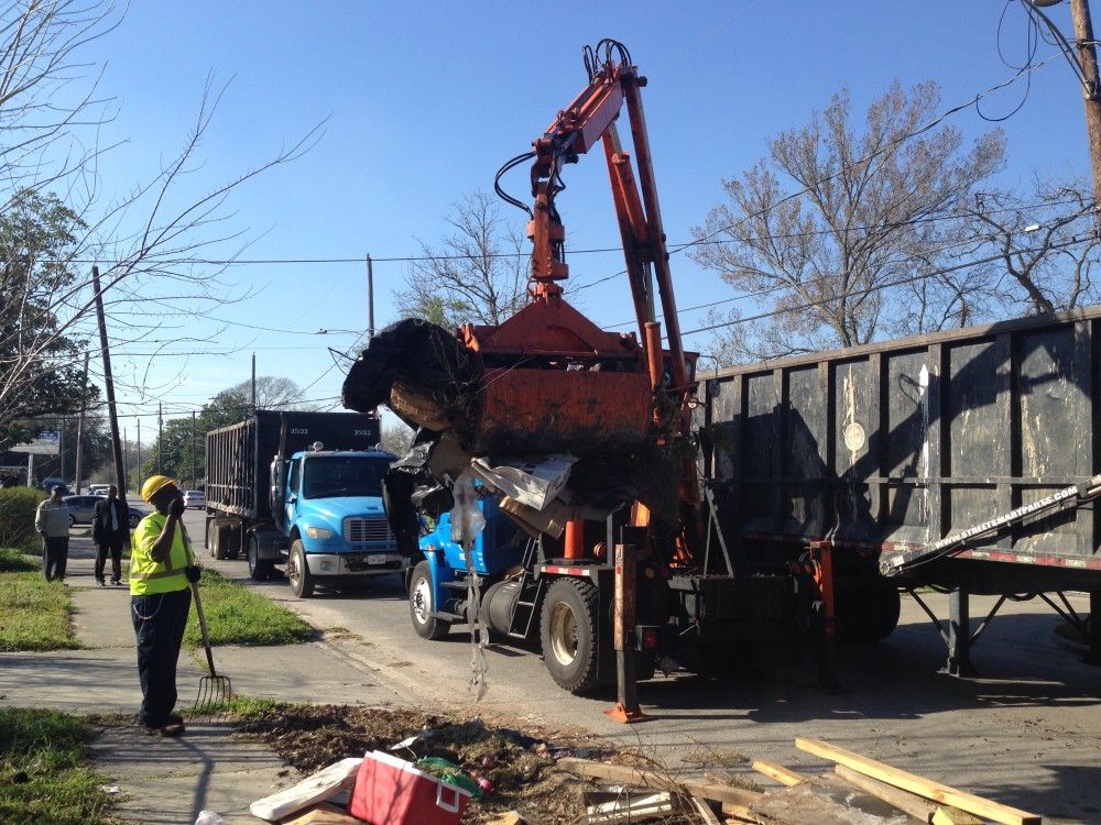 Kenneth Munson, on the left hand side of the photo, a worker with the Department of Solid Waste Management, cleans up heavy trash sites in District B as part of the City's plan to reduce breeding grounds for mosquitoes and subsequently combat the spread of diseases they may carry, such as the Zika virus.