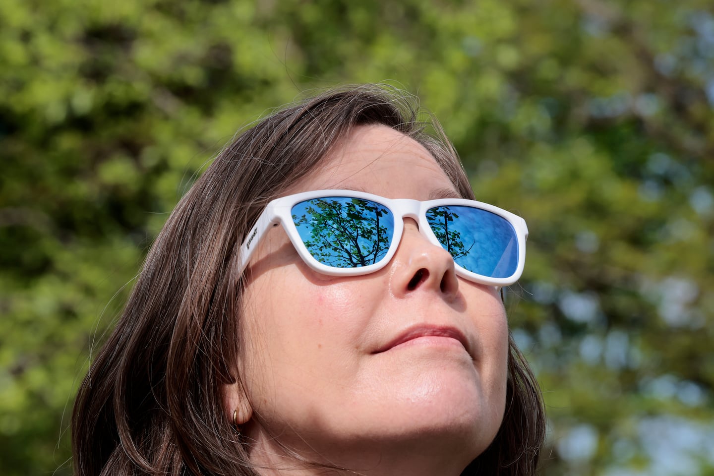 A tulip tree Boukili planted in Somerville is reflected in her sunglasses.