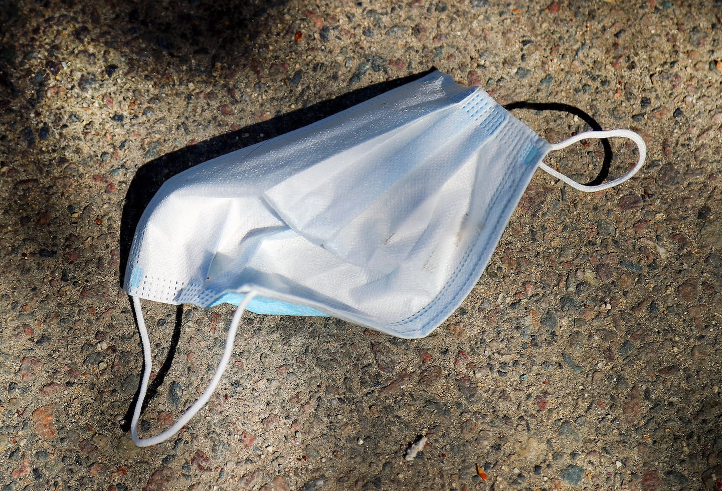 A mask is seen on a sidewalk in Boston Common on May 5, 2023.