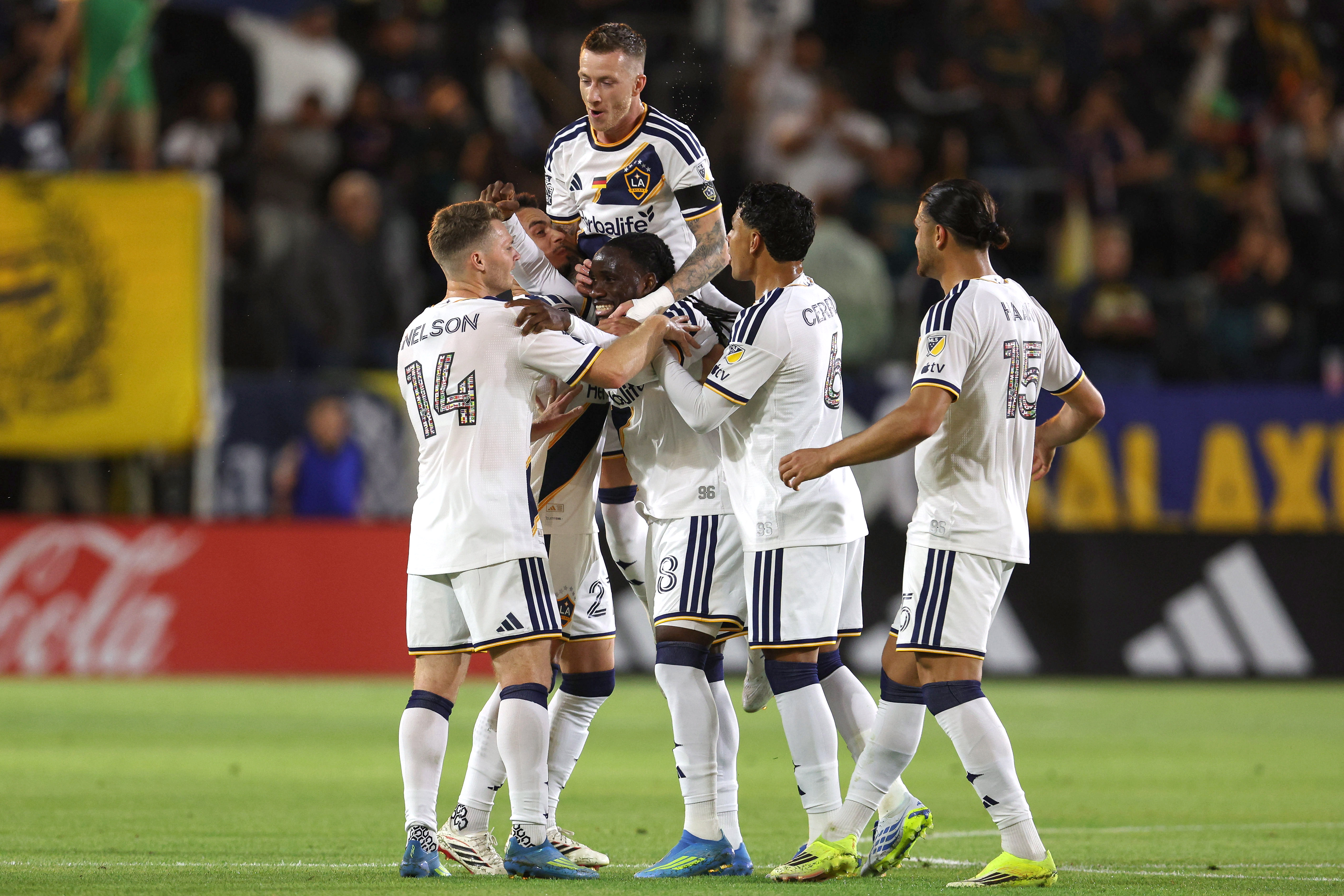 Galaxy midfielder Marco Reus, top, jumps on forward Joseph Paintsil...