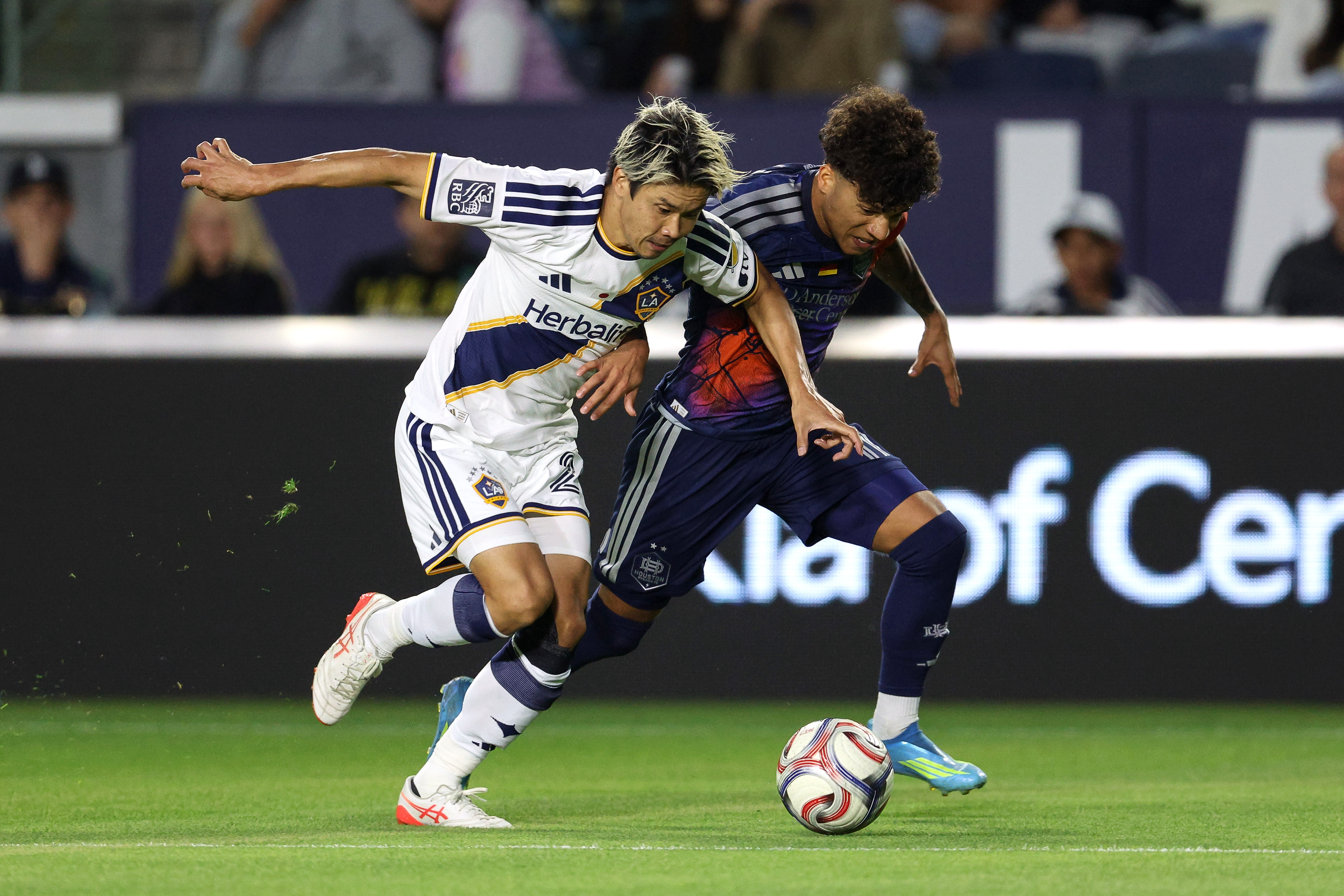 Galaxy defender Miki Yamane, left, defends against Houston Dynamo forward...