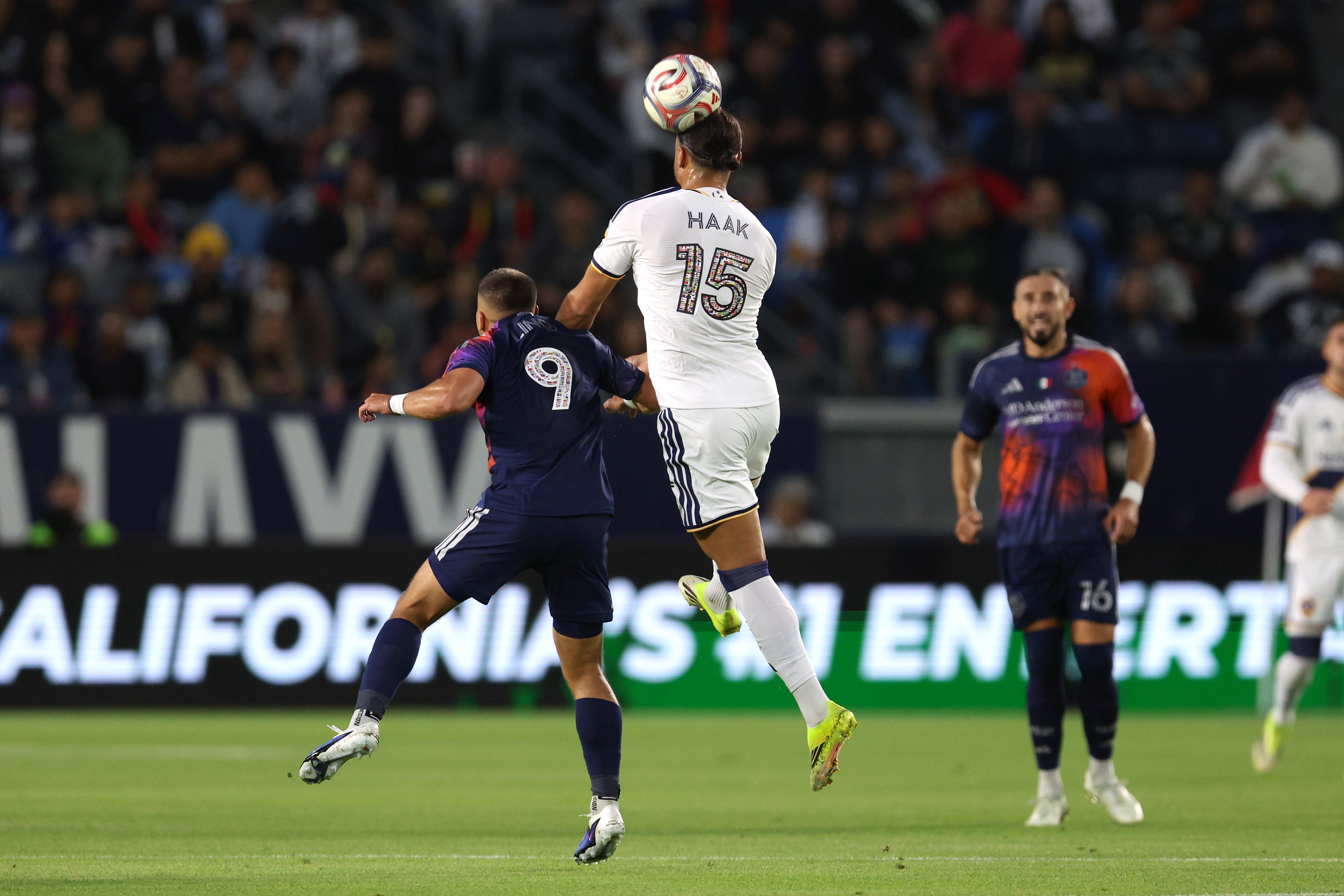Galaxy midfielder Justin Haak (15) heads the ball against Houston...