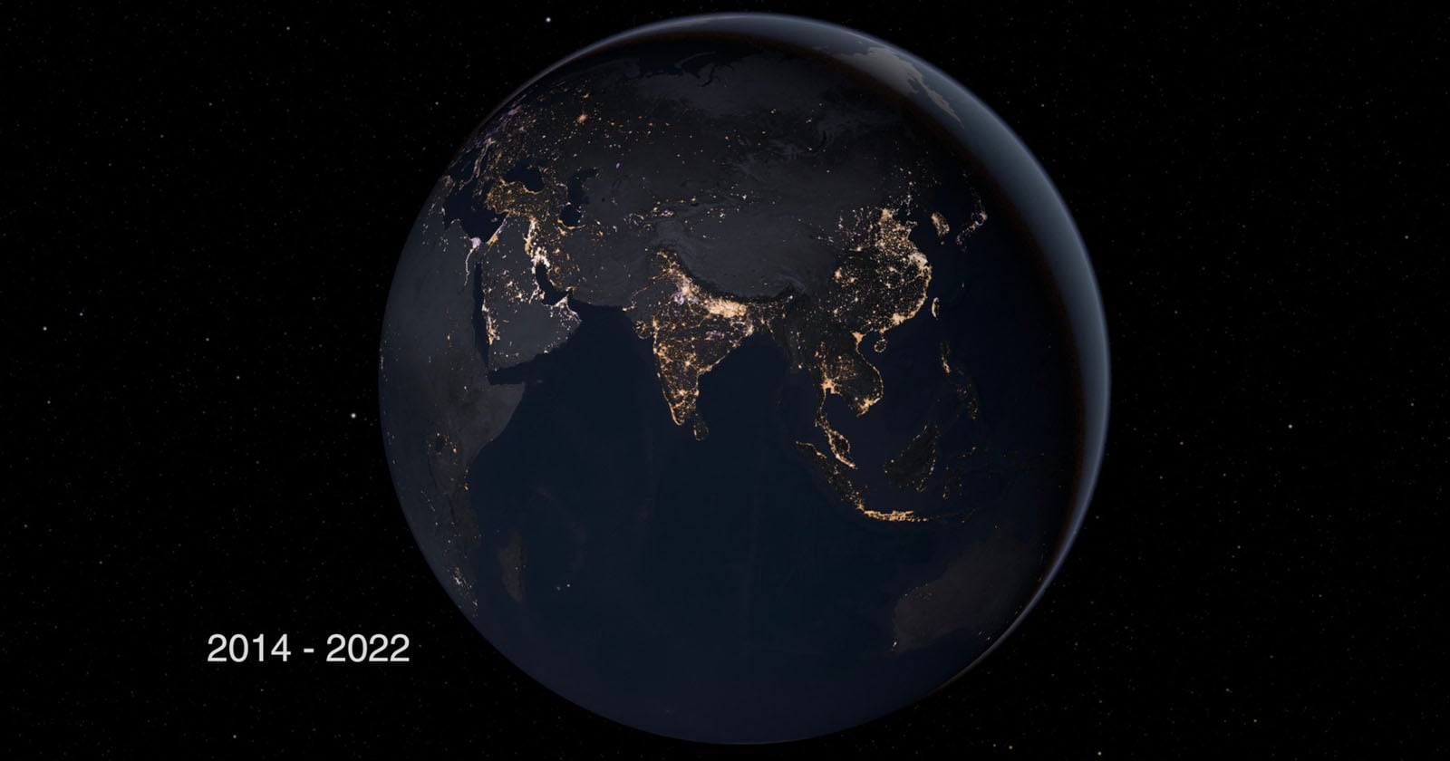 A view of Earth from space at night, showing illuminated city lights across Asia, including India, China, and Southeast Asia. The years "2014 - 2022" are displayed in the bottom left corner.