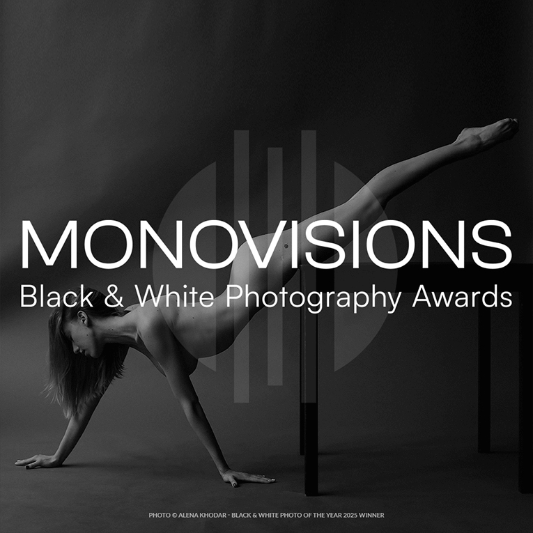 A dynamic black and white image featuring a model balancing on a sleek table in a striking artistic pose