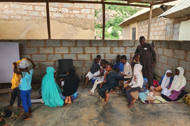 Mr Akanji, an Islamic tutor at Nurul Bayan, in the midst of his students