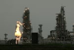 FILE - In this April 2, 2010, file photo, a Tesoro Corp. refinery, including a gas flare flame that is part of normal plant of operations, is shown in Anacortes, Wash., after an overnight fire and explosion at the refinery killed seven people who were working at the plant.