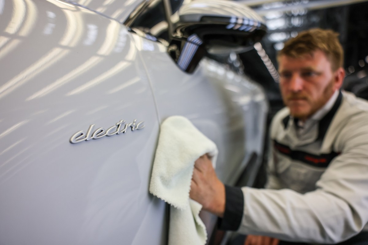 A Porsche employee checks an all-electric Porsche Macan in quality control at the Leipzig plant.