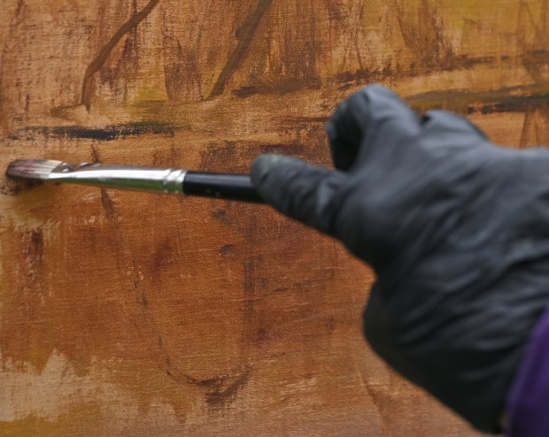 A paint brush touches a canvas.