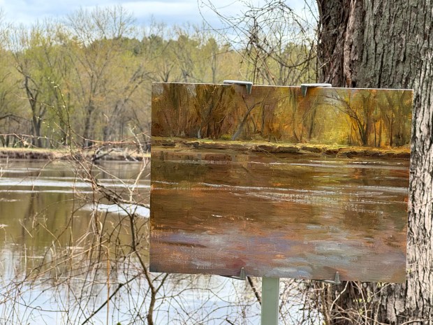 A river scene painting with the river in the background. 