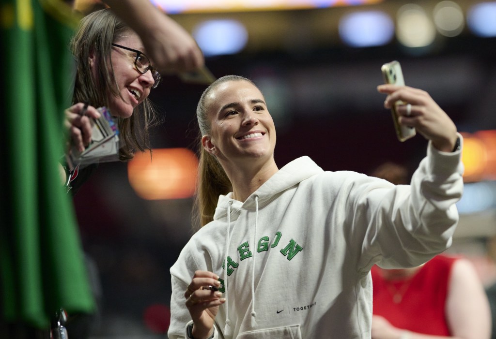 Sabrina Ionescu, who starred for the Oregon Ducks, takes a selfie with a fan before the Liberty's 98-96 loss to the Fire on May 12, 2026 in Portland, Ore.