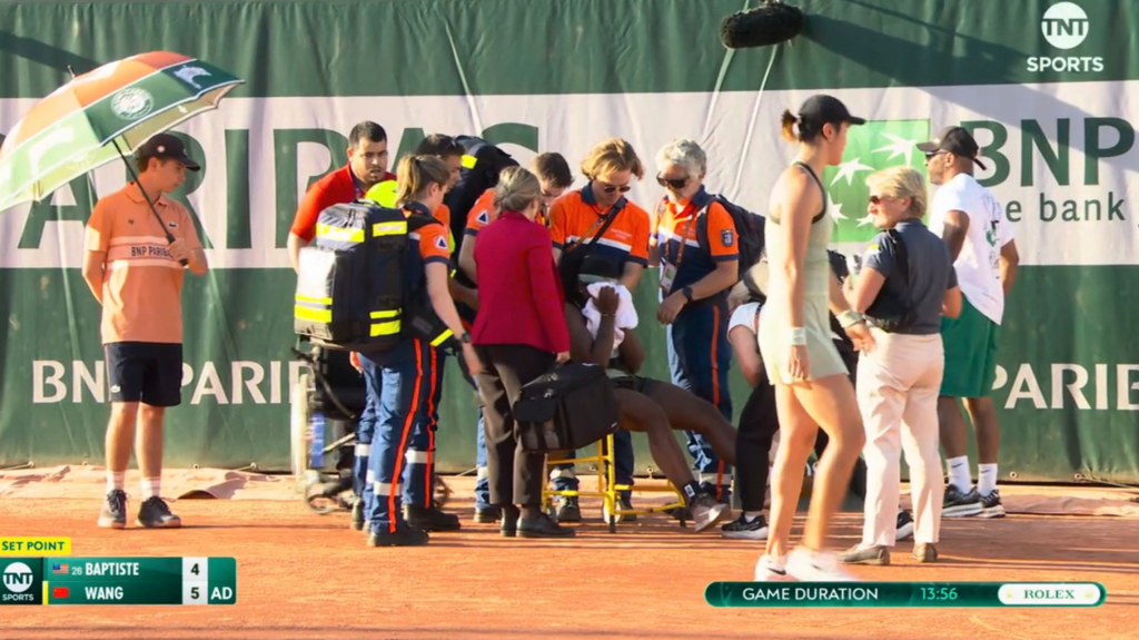 Hailey Baptiste is helped off the court in a wheelchair