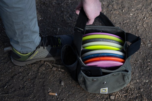 Jacob Morris grabs his NutSac branded disc golf bag while heading down-course on Friday, Feb. 6, 2026, at Memorial Park and Johnny Roberts Disc Golf Course in Arvada, Colo. (Photo by Timothy Hurst/The Denver Post)