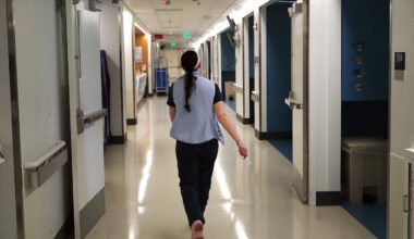 A nurse walked the hallway at Mass General Brigham’s Newton-Wellesley Hospital, where nurses and doctors hold weekly huddles to review quality metrics.