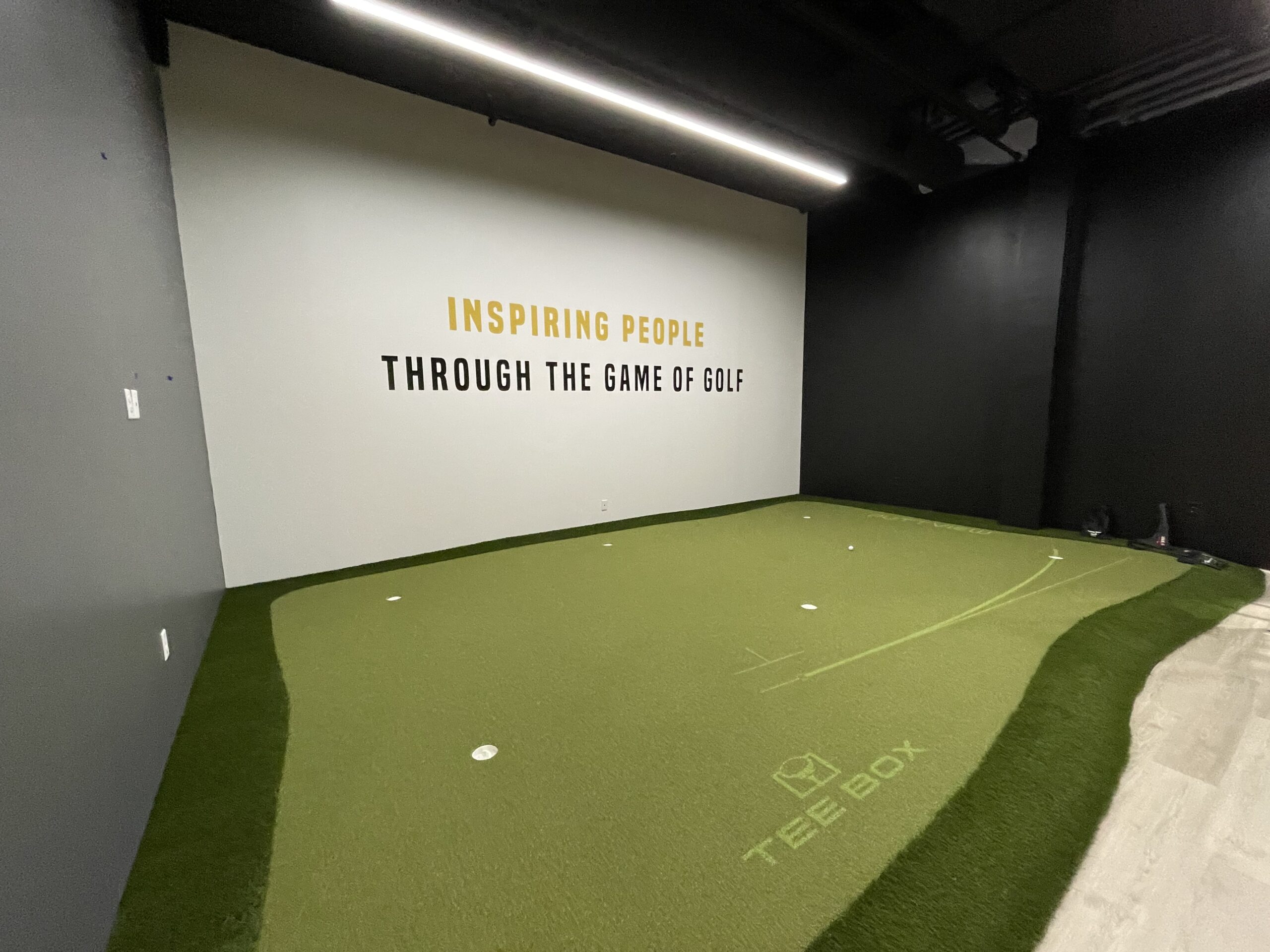 Indoor golf venue Tee Box ready to tee off at Regency 3 Tee Box putting green scaled
