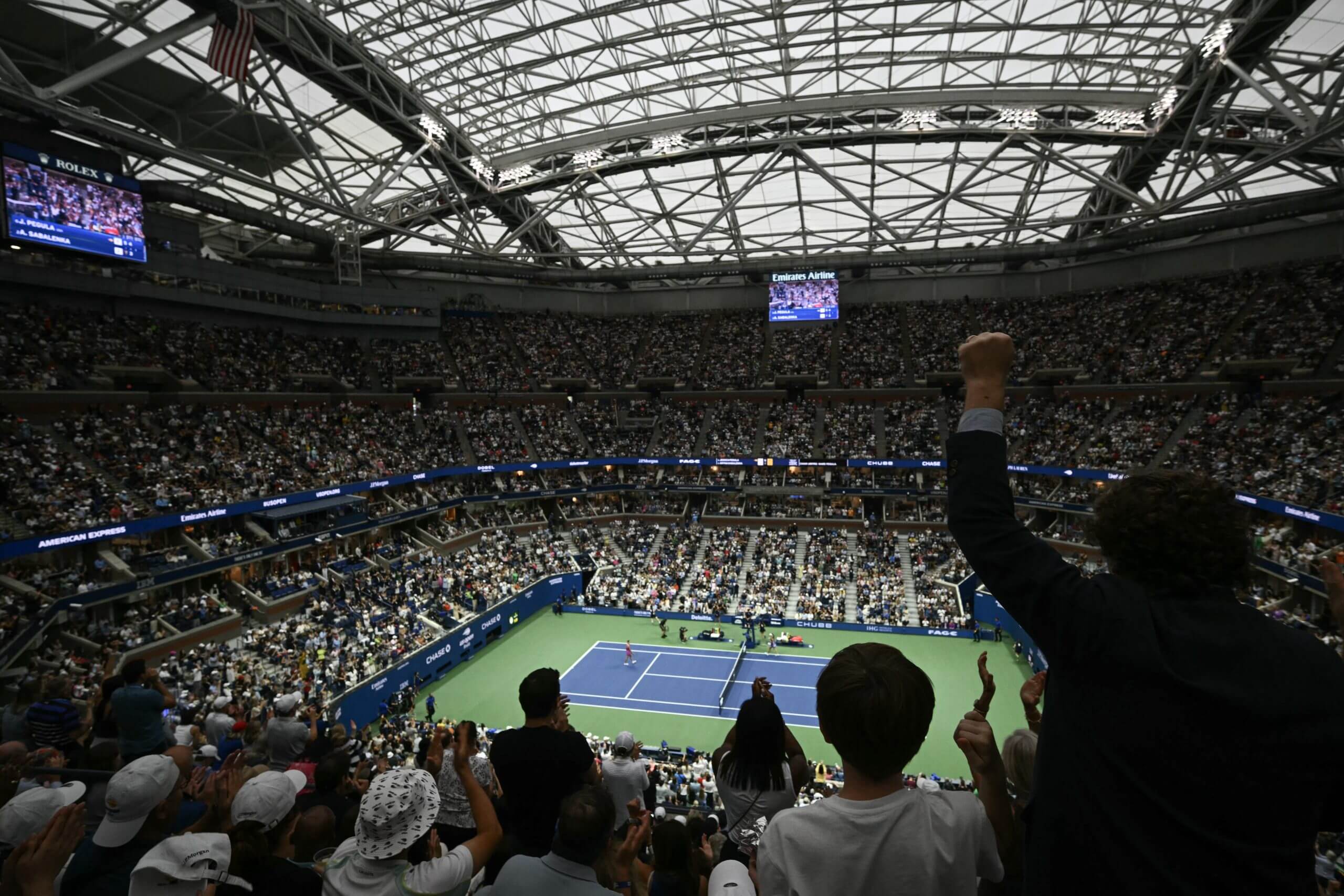 Fans cheer in the stands of Arthur Ashe Stadium during a tennis match at the U.S. Open.