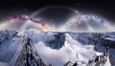 Snow-covered mountain peaks under a dark sky with bright, colorful arcs resembling galaxies and nebulae, creating a surreal and otherworldly landscape.