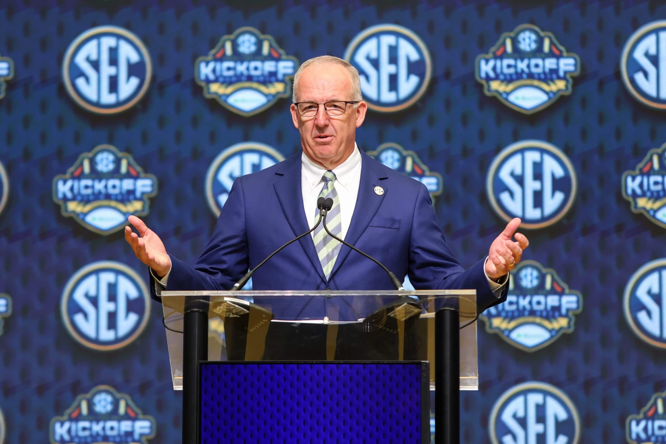 Greg Sankey stands behind a podium.